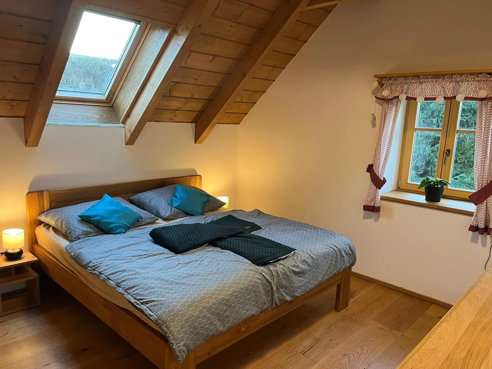 Dvoulůžková ložnice pod dřevěným krovem