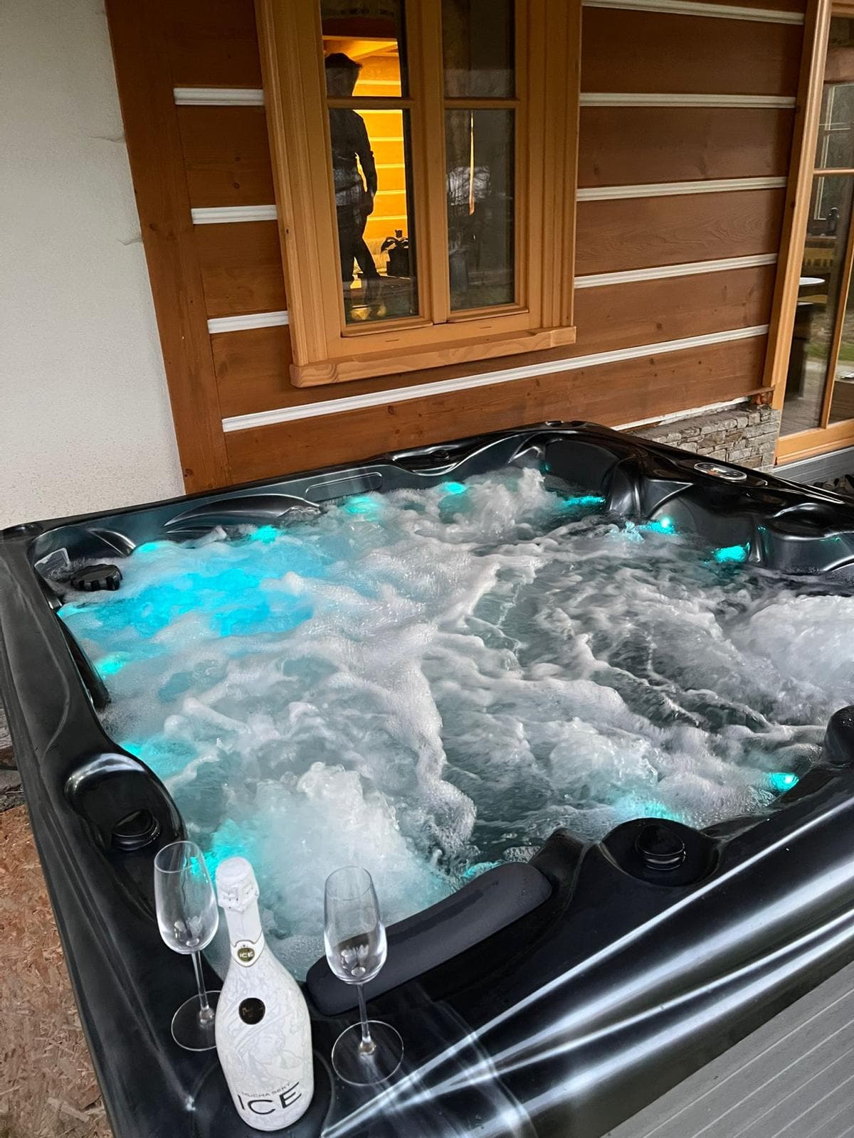 Vířivka s modře podsvícenou hladinou za soumraku