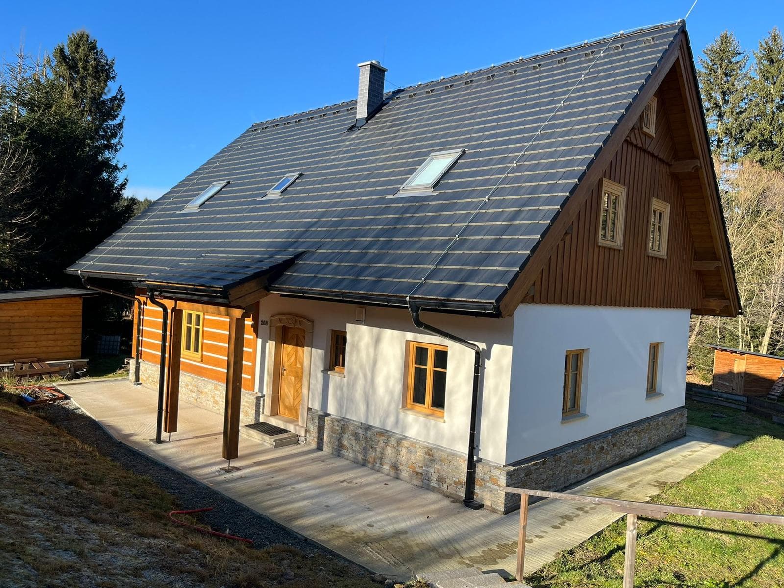 Roubenka Vanedi s dřevěnou verandou, pohled od cesty